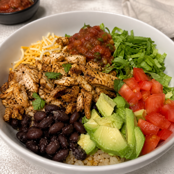 Chicken taco bowl with black beans avocado lettuce tomatoes and salsa
