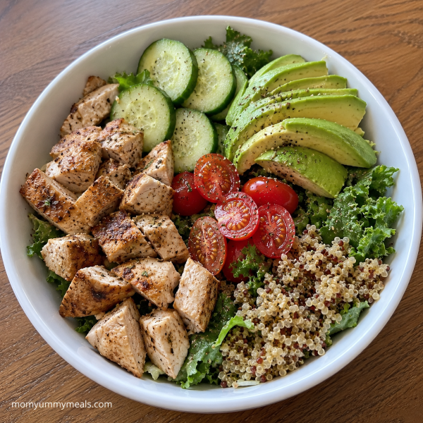 Chicken avocado bowl with greens cucumber tomatoes and quinoa