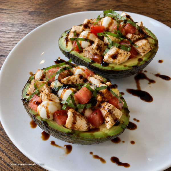 Chicken caprese stuffed avocado with tomatoes mozzarella and fresh basil