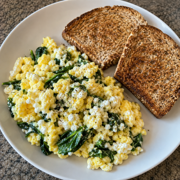 Cottage cheese scrambled eggs with spinach and whole grain toast