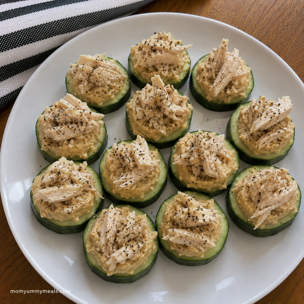 Cucumber bites topped with hummus and cooked chicken