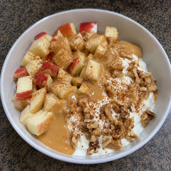 Greek yogurt breakfast bowl with apples cinnamon walnuts and peanut butter