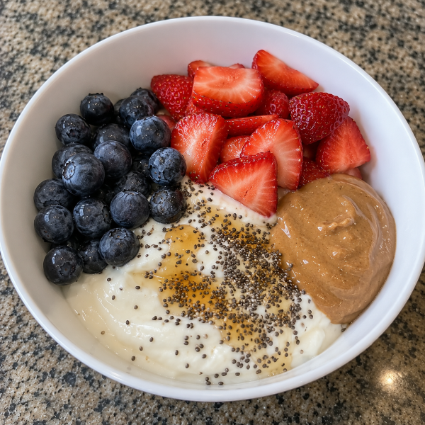 Greek yogurt breakfast bowl with strawberries blueberries chia seeds and peanut butter