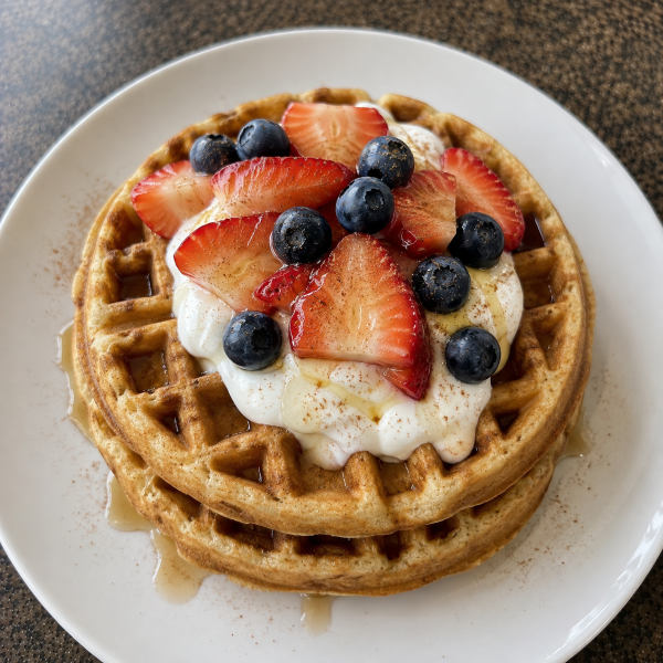 High protein waffles topped with Greek yogurt strawberries and blueberries