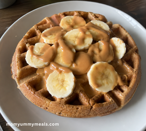Peanut butter banana high protein waffles topped with sliced banana and peanut butter
