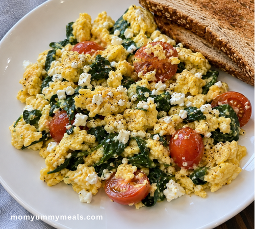 Healthy scrambled eggs with spinach feta cheese and tomatoes