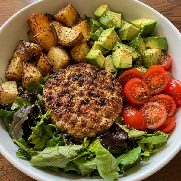 Turkey burger bowl with greens avocado tomatoes and roasted potatoes